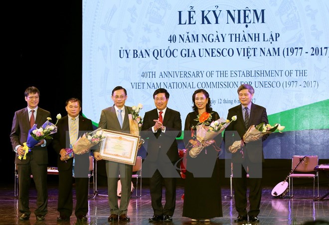 Phó Thủ tướng Phạm Bình Minh trao Bằng khen của Thủ tướng Chính phủ cho Uỷ ban Quốc gia UNESCO Việt Nam. (Ảnh: Nguyễn Dân/TTXVN)