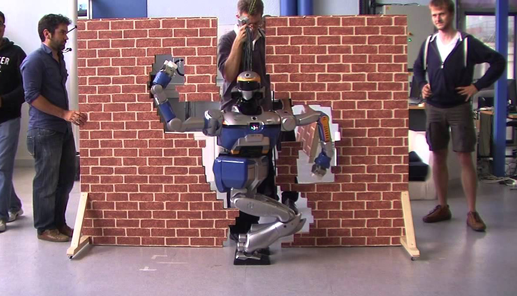  Robot HRP2 Promet đi qua khe hẹp trên bức tường gạch - Ảnh: YOUTUBE