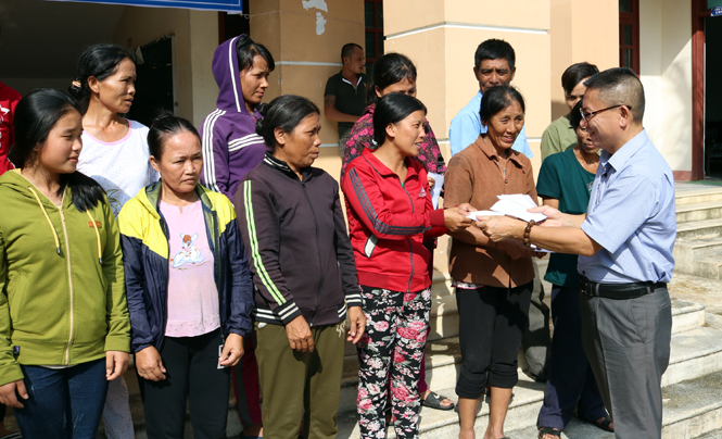 Đại diện Công ty TNHH Đầu tư và Du lịch lữ hành Asia Master trao quà cho bà con vùng bão xã Kim Hóa, huyện Tuyên Hóa.