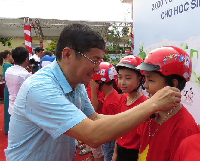 Đồng chí Trần Tiến Dũng, Tỉnh ủy viên, Phó Chủ tịch UBND tỉnh đội mũ bảo hiểm cho các em học sinh Trường tiểu học Hải Thành.