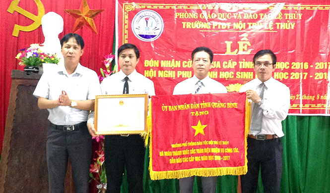 Lãnh đạo Trường phổ thông dân tộc nội trú Lệ Thủy đón nhận cờ “Đơn vị dẫn đầu các cấp học” của UBND tỉnh.