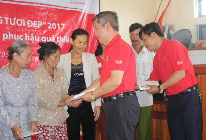 Đại diện Công ty Bảo hiểm nhân thọ Dai-Ichi Việt Nam trao quà hỗ trợ thiệt hại cho các hộ gia đình tại xã Quảng Sơn (thị xã Ba Đồn).