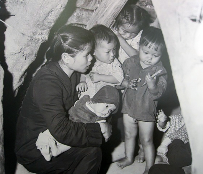 Cô mẫu giáo và các cháu đang tránh bom (Bức ảnh được Bảo tàng Quảng Bình, Bảo tàng Phụ nữ Việt Nam trưng bày).