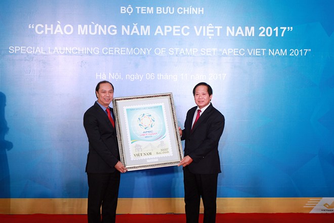 Bộ trưởng Trương Minh Tuấn (phải) tặng tranh Tem APEC cho Thứ trưởng Bộ Ngoại giao Nguyễn Quốc Dũng. (Ảnh: VNPost)