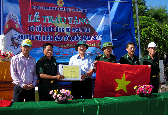 Đại diện lãnh đạo Công ty Điện lực Quảng Bình trao 1.000 lá cờ Tổ quốc cho ngư dân đang đánh bắt tại các ngư trường truyền thống.