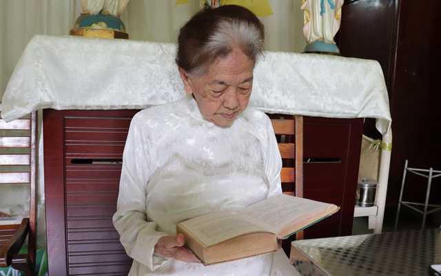 Dù 102 tuổi nhưng bà Ngô Thị Hai vẫn duy trì thói quen đọc sách - Ảnh: XUÂN MAI