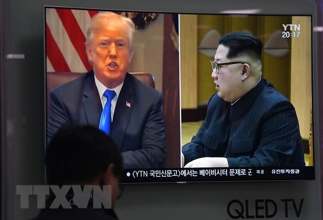 Người dân theo dõi qua truyền hình hình ảnh Tổng thống Mỹ Donald Trump (trái) và Nhà lãnh đạo Triều Tiên Kim Jong-un ngày 24-5 vừa qua. (Ảnh: AFP/TTXVN)