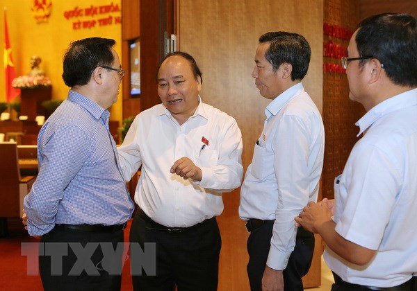 Thủ tướng Nguyễn Xuân Phúc trao đổi với các đại biểu Quốc hội trong giờ giải lao. (Ảnh: Doãn Tấn/TTXVN)