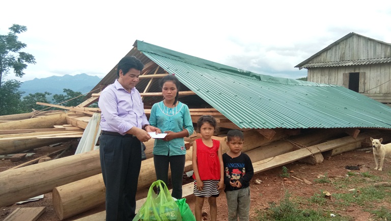 Đại diện UBND huyện Minh Hóa trao tiền hỗ trợ cho gia đình anh Hồ Phương